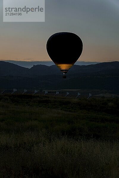 Ronda  malaga  spanien Silhouette eines Heißluftballons in der Morgendämmerung  beleuchtet von Flammen