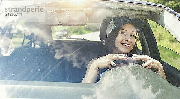 Schöne erwachsene glückliche Frau fährt ihr Auto im Sommer Tag