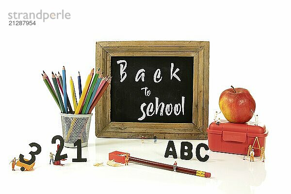 Tafel mit dem Text Zurück zur Schule und der Vorbereitung auf das neue Schuljahr durch Miniaturen