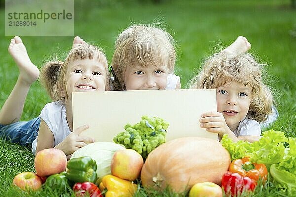 Gruppe glücklicher Kinder mit Obst und Gemüse im Freien im Frühlingspark