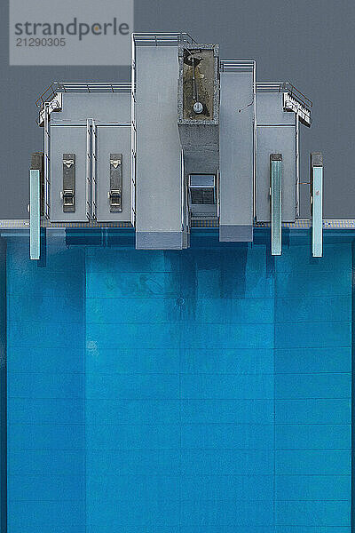 View from above diving platforms and diving boards above blue swimming pool