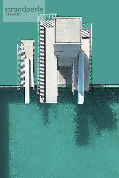 View from above diving platforms and diving boards above turquoise blue swimming pool