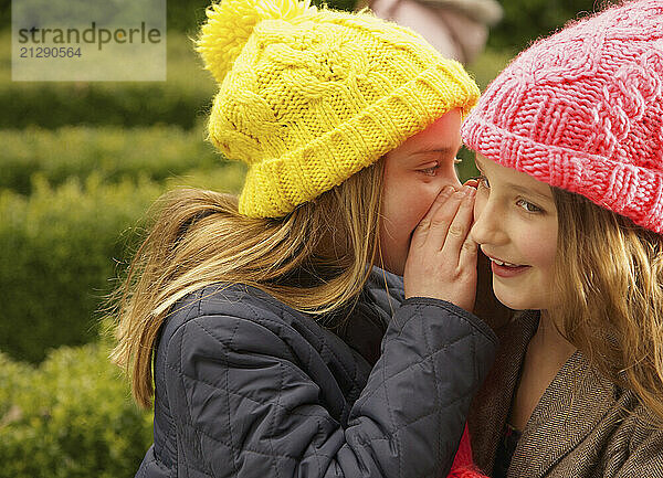 Young Girl Whispering in Friends Ear