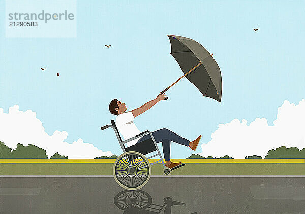 Man in wheelchair with umbrella blowing in wind along rural field