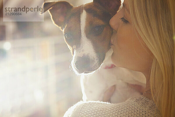 Young Woman Kissing Dog