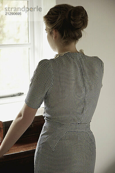 Back View of Woman Looking Out of Window