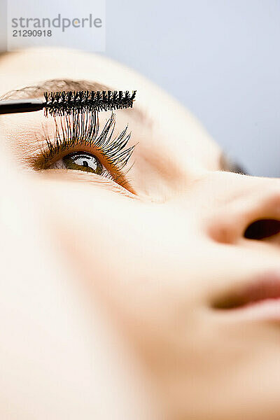 Extreme close up of a woman applying mascara