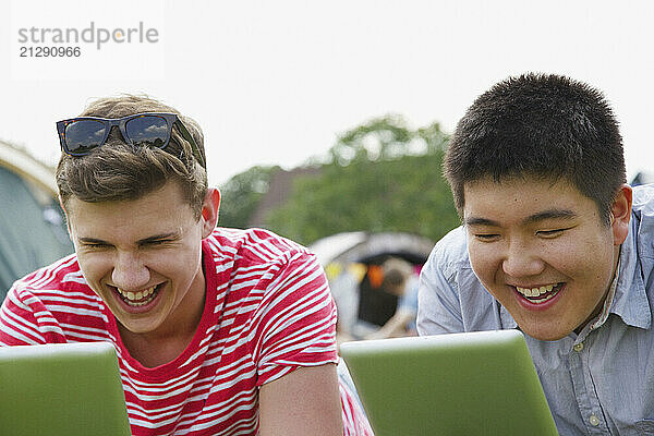 Laughing Teenage Boys Using Tablets