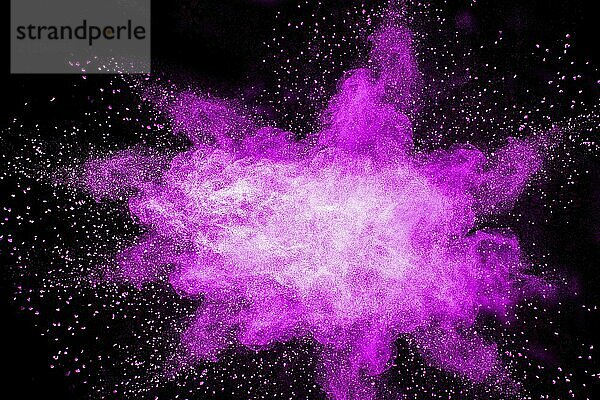 Purple color powder explosion cloud on black background.Closeup of purple dust particles splash on background