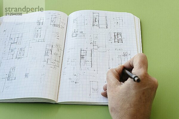 Architect works drawing sketches on notebook on green background