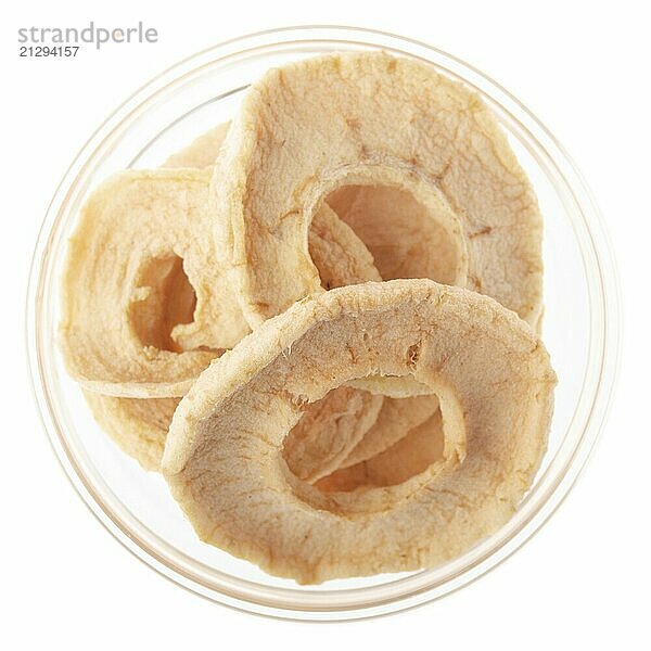 Dried apple rings in glass bowl isolated on white background flat lay closeup view