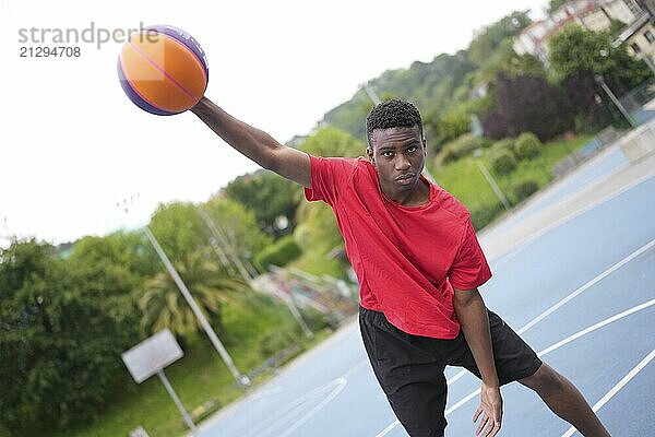 Portrait of a cool african american teen in an urban basketball outdoor court