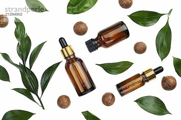 Dropper bottles with macadamia nut essential oil on white table flat lay