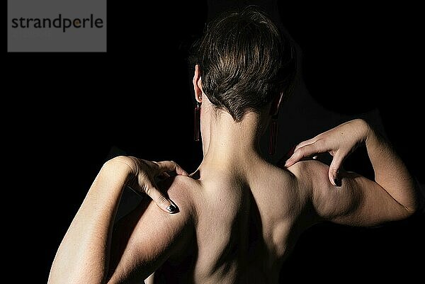 Thirty year old woman with naked torso  showing her muscles in a studio portrait  Brussels