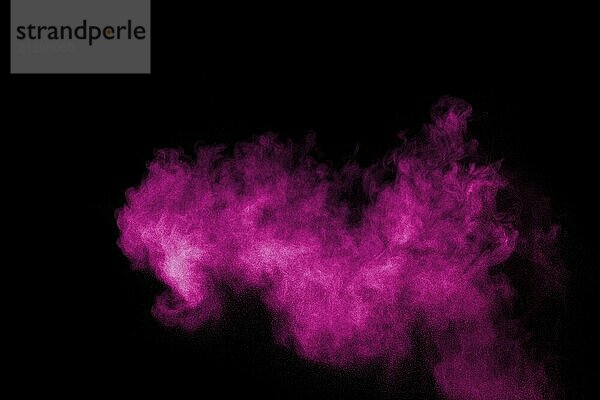 Pink powder explosion on black background.Pink dust splash cloud on dark background