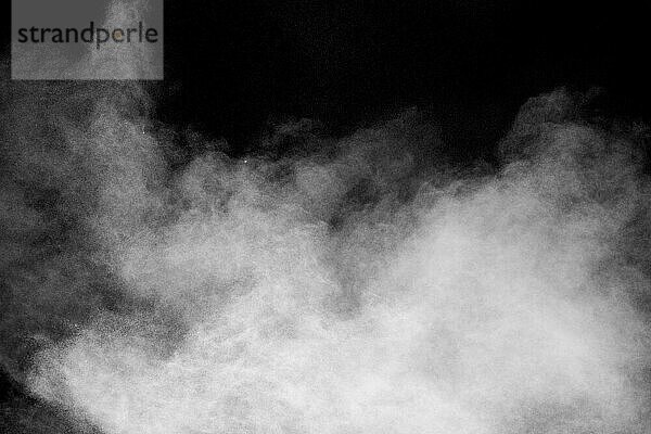 White dust cloud in the air.Abstract white powder explosion against black background