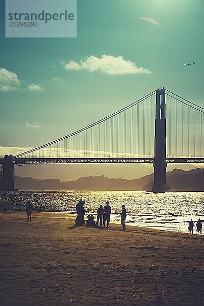 A Silhouetted Group Of Friends On The Beach Under Golden Gate Bridge San Francisco