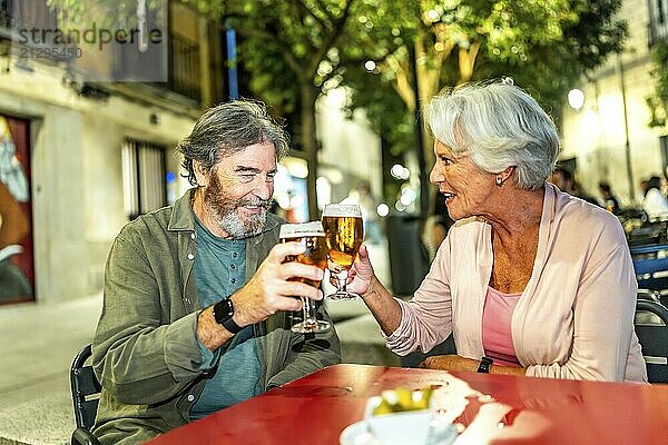 Senior couple toasting in a sidewalk bar in the city of Madrid