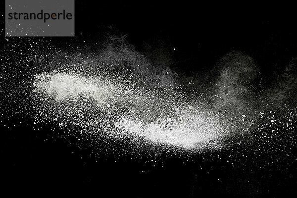 Bizarre forms of white powder explosion cloud against black background.White dust particles splash