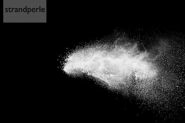 Bizarre forms of white powder explosion cloud against black background.White dust particles splash