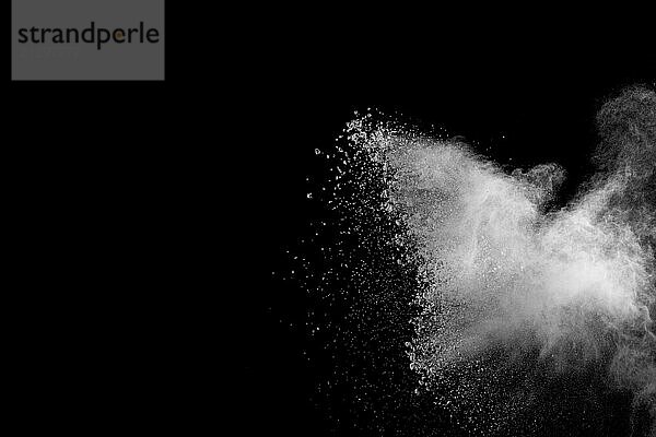 White powder explosion isolated on black background. White dust particles splash.Color Holi Festival