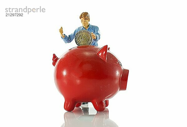 Red piggy bank filled with euro coin by man puppet isolated on white background  symbol for saving money