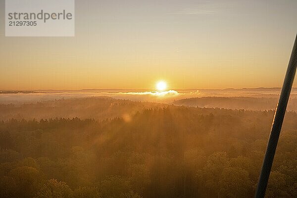 The sun rises over misty forests  bathing the landscape in warm light  Herrenberg  Schönbuchturm  Germany  Europe