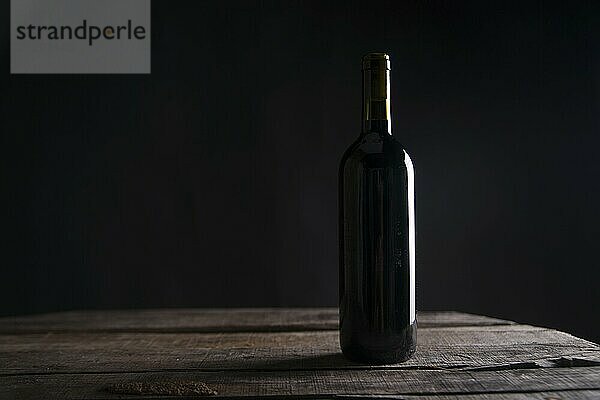 A bottle of red wine glass in dark background