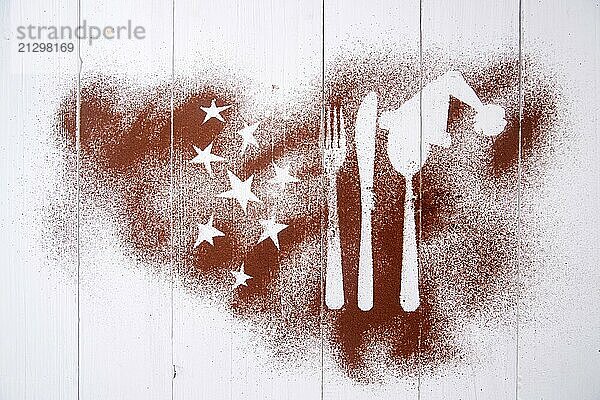 Representation of the Christmas holiday with cutlery on white background and a dusting of cocoa