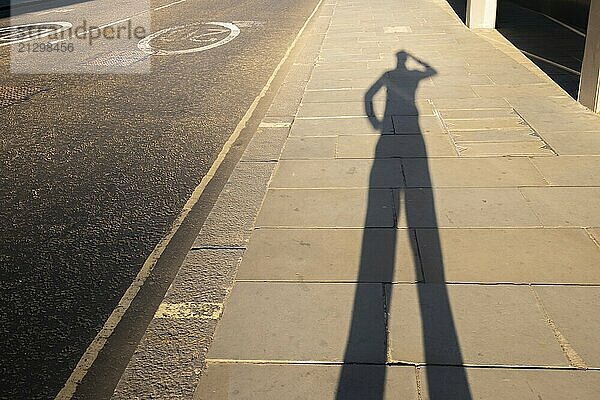 Personal perspective shadow of a man scratching his head at sunset leaving the office