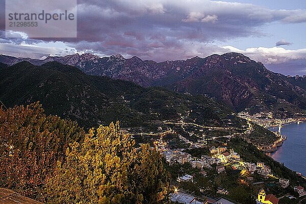 Aerial view of a village on the fantastic Amalfi Coast in the evening. Illuminated village and mountains behind in Campania Italy. And terraces (can be grape or other crops)