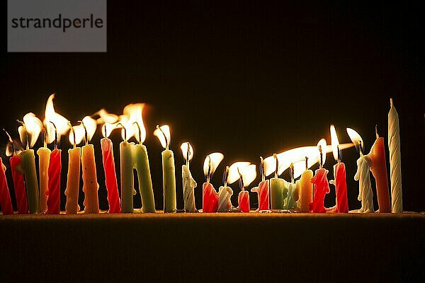 Series of small lighted candles on a black background