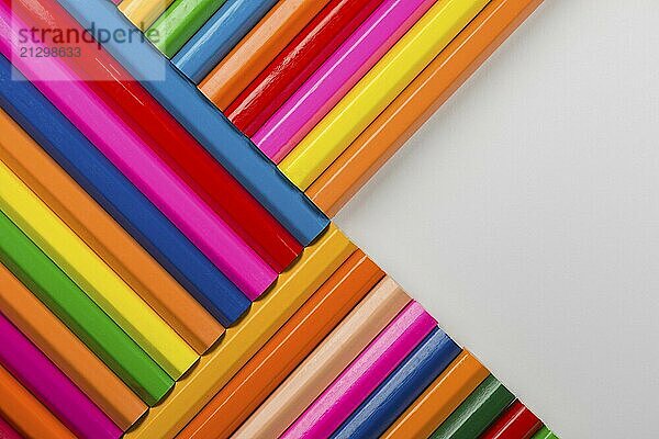 Abstract composition of a set wooden colour pencils against a white background