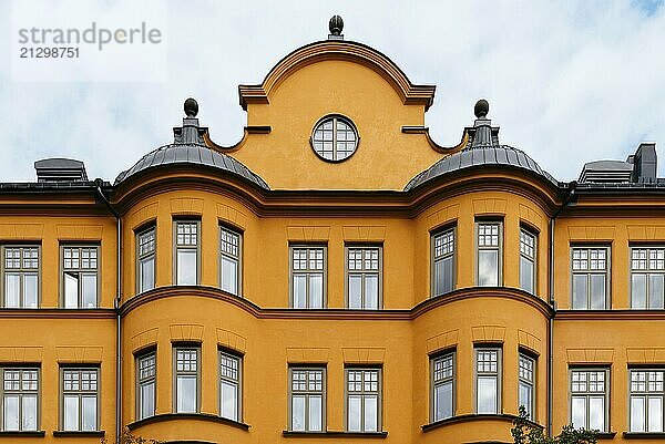 Traditional residential house in Stockholm. Yellow painted facade against sky