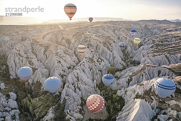 Several hot air balloons fly over a rocky landscape in the morning light  Göreme  Turkey  Asia