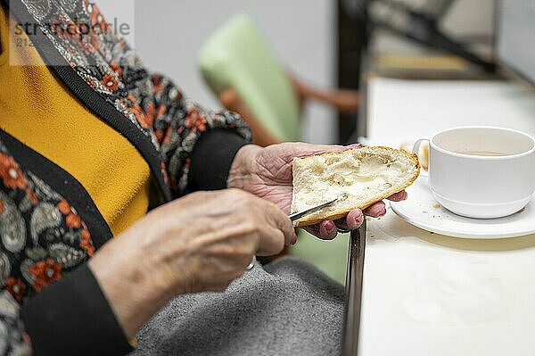 Close up of elderly woman enjoying breakfast.