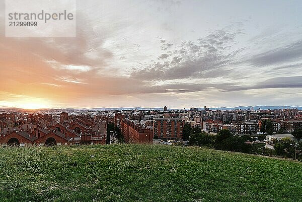 Madrid cityscape at dusk from a residential district and mountain range at background. Cerro del Tio Pio park