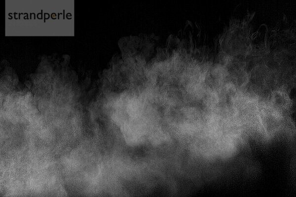 Bizarre forms of white powder explosion cloud against black background.White dust particles splash