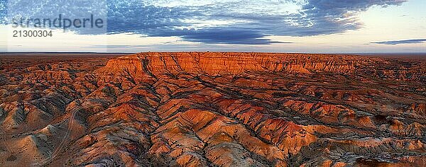 Aerial panorama of textural colorful striped canyons Tsagaan suvarga  White stupa at sunrise. Ulziit soum  Dundgovi province  Mongolia  Asia