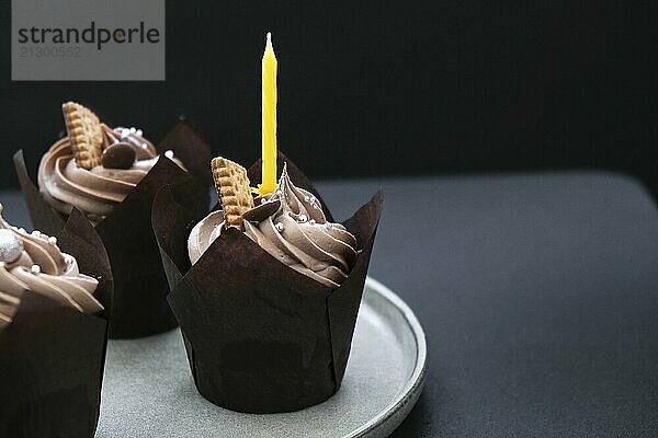 Delicious chocolate cupcakes with cream on dark background. Three chocolate muffin. Birthday cake party. Homemade Chocolate Cupcake