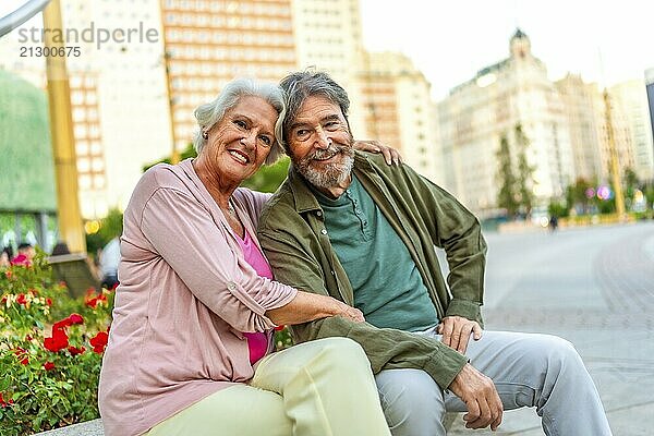 Senior caucasian male and female lovers sitting on city bench together