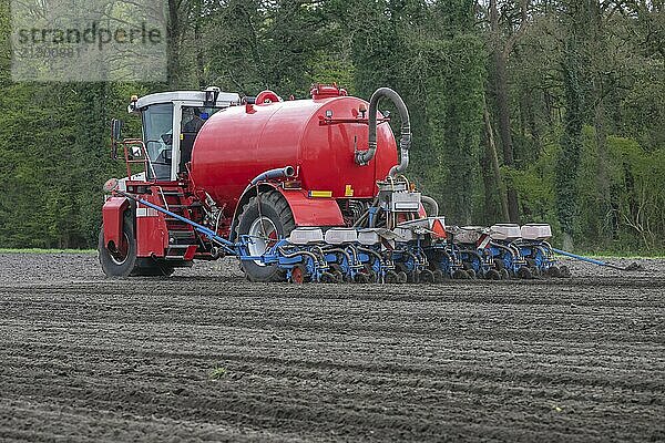 A slurry injector planting maize on arable land in the east of the Netherlands in spring