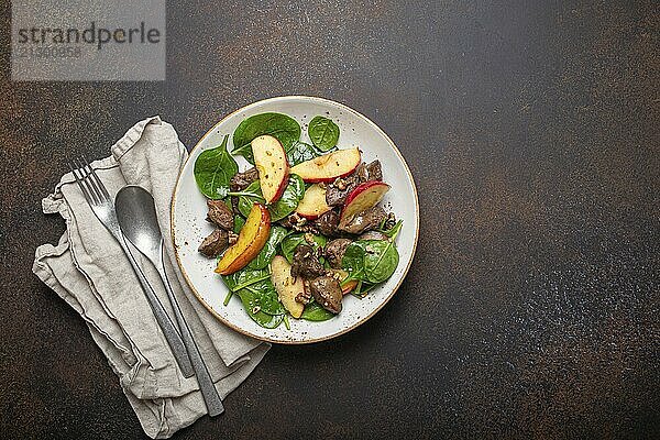 Healthy Salad with Iron Rich Ingredients Chicken Liver  Apples  Fresh Spinach and Walnuts on White Ceramic Plate  Dark Brown Rustic Stone Background Top View Copy Space  food photography  food photography