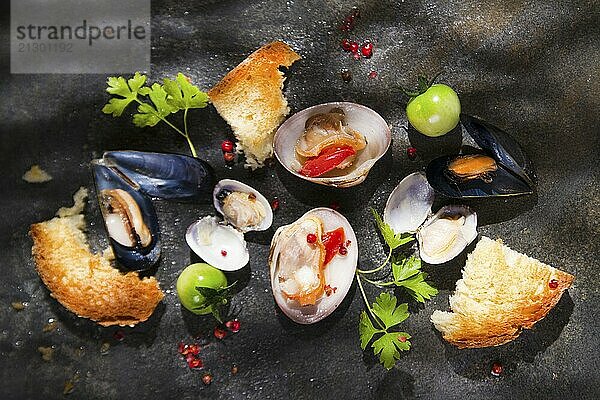 Presentation of a soup with seafood on a black background