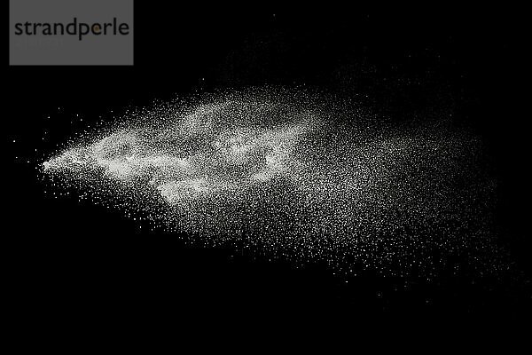 Freeze motion of white particles on black background. Abstract white dust explosion