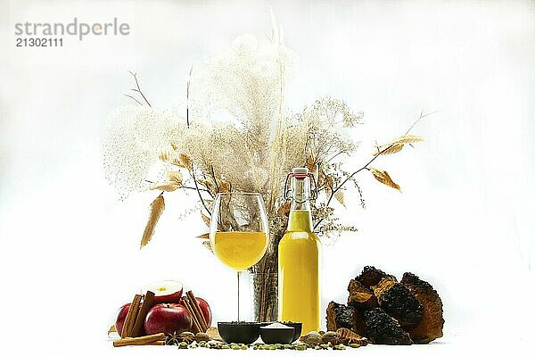 Freshly brewed Kombucha is seen isolated against a white backdrop with natural flora and main elements of the blended green tea. An apple cider beverage