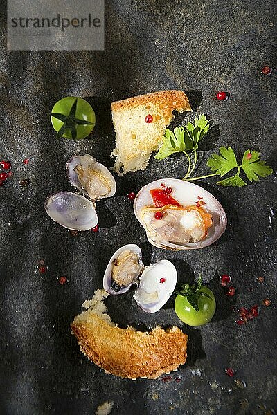 Presentation of a soup with seafood on a black background