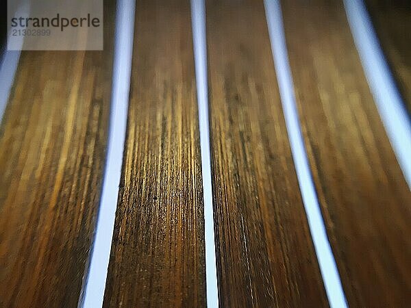 Abstract shot of wooden strips in macro and selective focus with yellow light on blue background