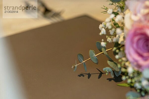 Close-up of a menu on a festively laid table with a bouquet of flowers