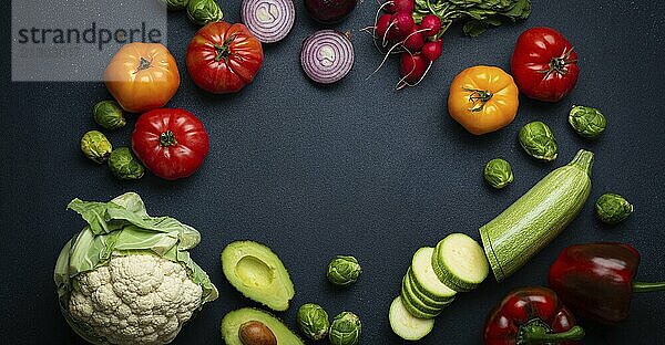 Different fresh various vegetables  cut zucchini  greenery on rustic dark background top view. Cooking vegetarian meal from healthy ingredients  diet food and nutrition concept  space for text  food photography  food photography